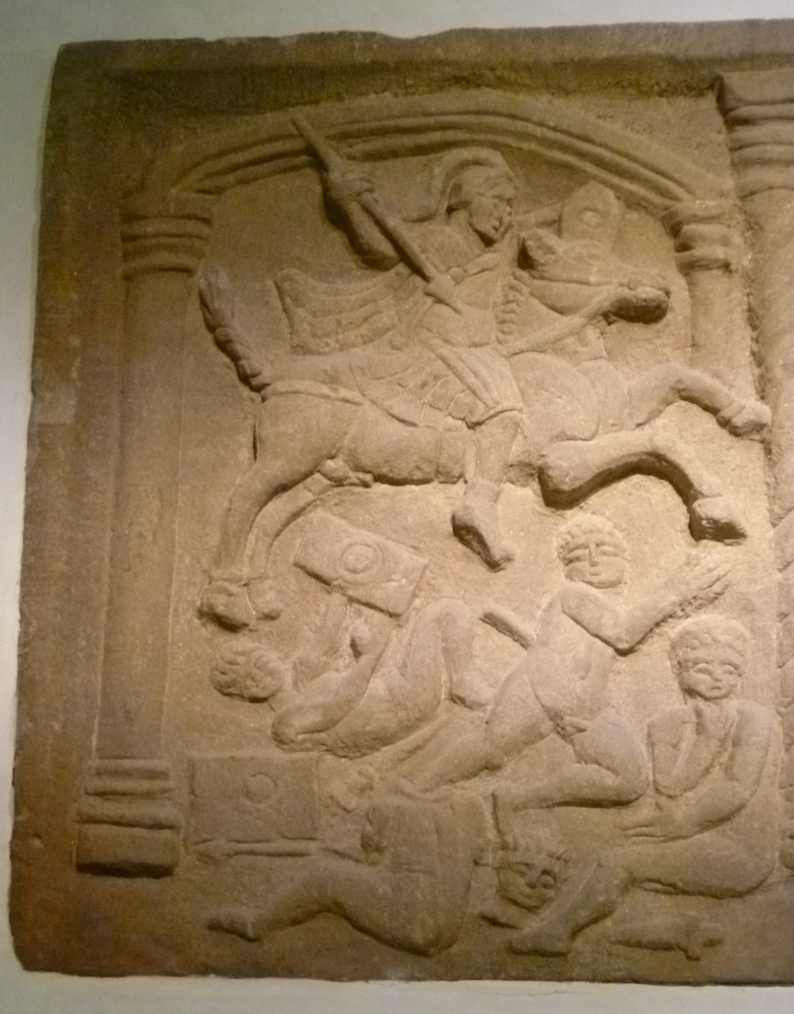 Bas-relief romain en grès : un cavalier charge 4 guerriers nus.