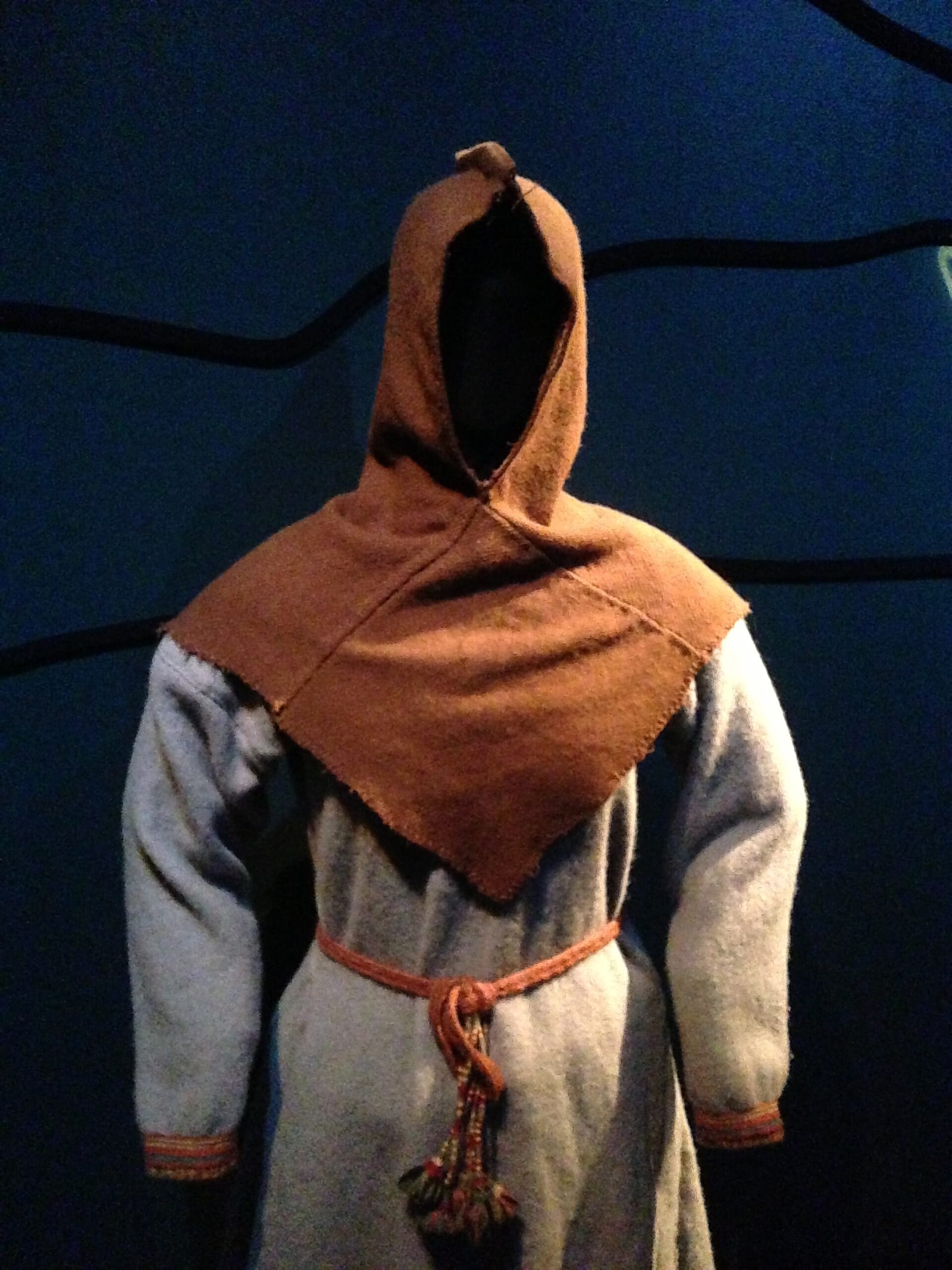 Tenue de Skjoldehamn présentée au musée : tunique de laine claire, ceinture et capuchon brun à pèlerine.