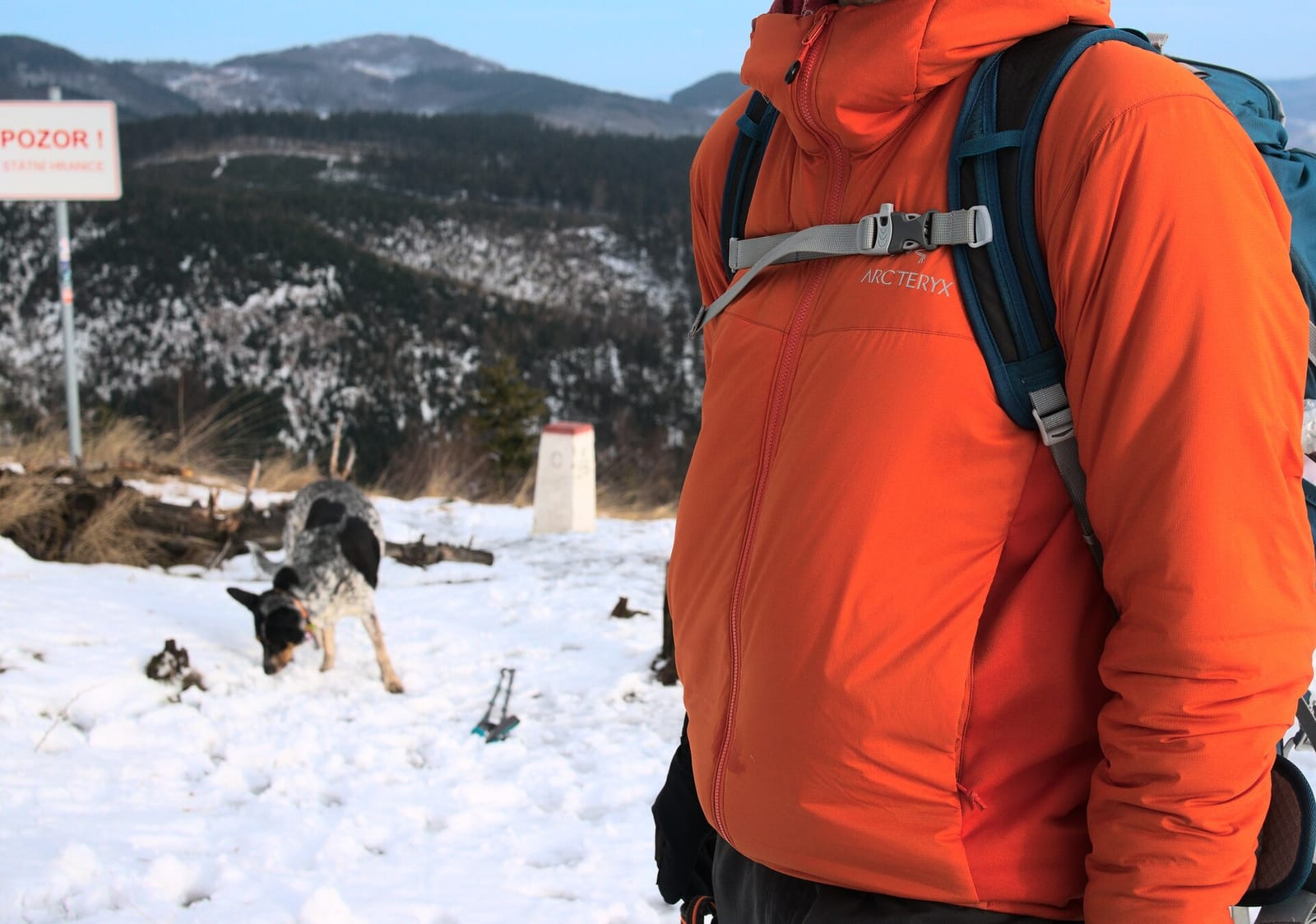 Randonneur en veste Arc'teryx Atom LT orange, dans la neige.